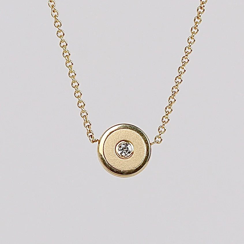 Retrouvai Mini compass pendant in brushed gold.