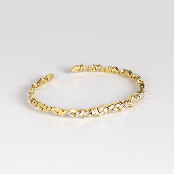 18k Zig Zag Firework Bangle in white diamond by Suzanne Kalan is a striking and prong set emerald baguettes on a trademarked zig zag fireworks setting with solid ends in 18k yellow gold form this flexible bangle cuff full of sparkle and texture. 1.5CT