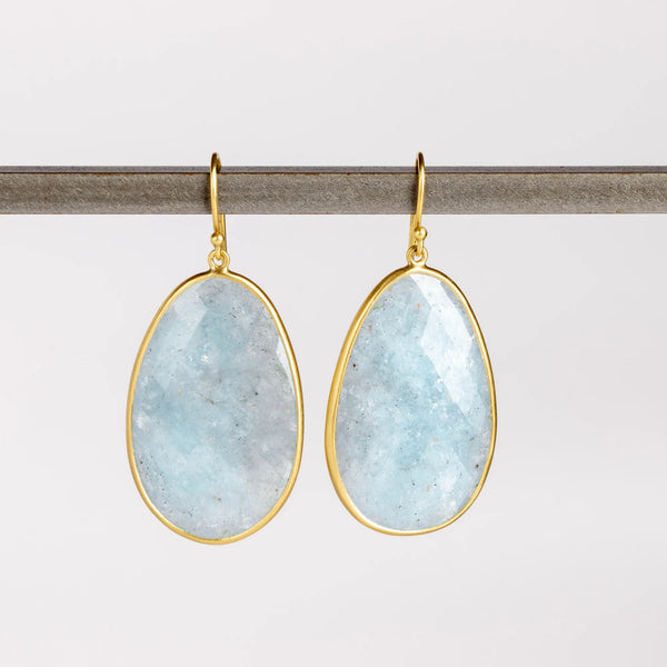 XL Aquamarine Egg Earrings designed by Tej Kothari are Extra large rustic and faceted aquamarine slices, bezel set in 18k yellow gold with gold ear wire on white background.