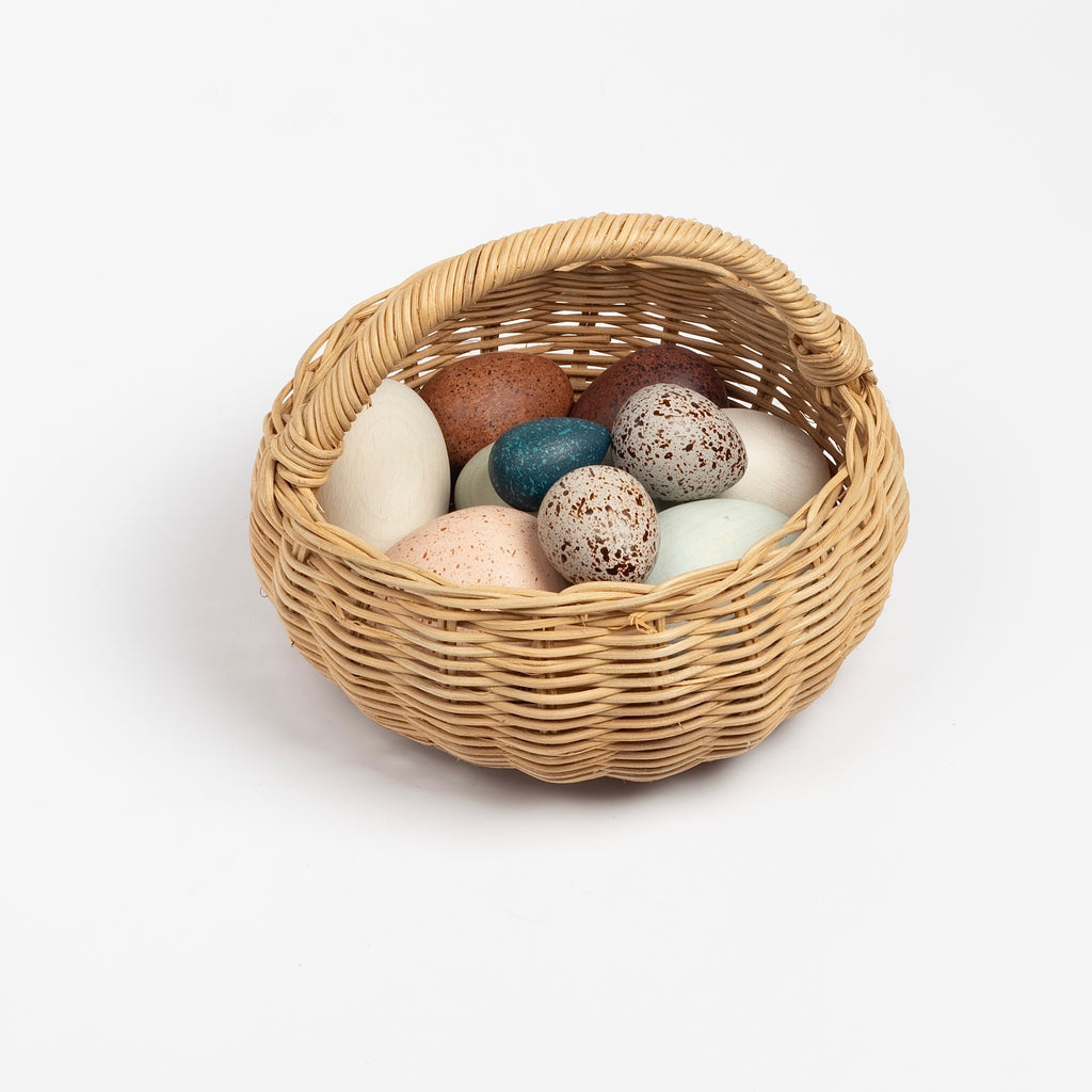 Birds eggs in a basket toy. A dozen of wooden eggs in muted colors with lovely details in a rattan basket. A great carry along toy. Made in Germany.
