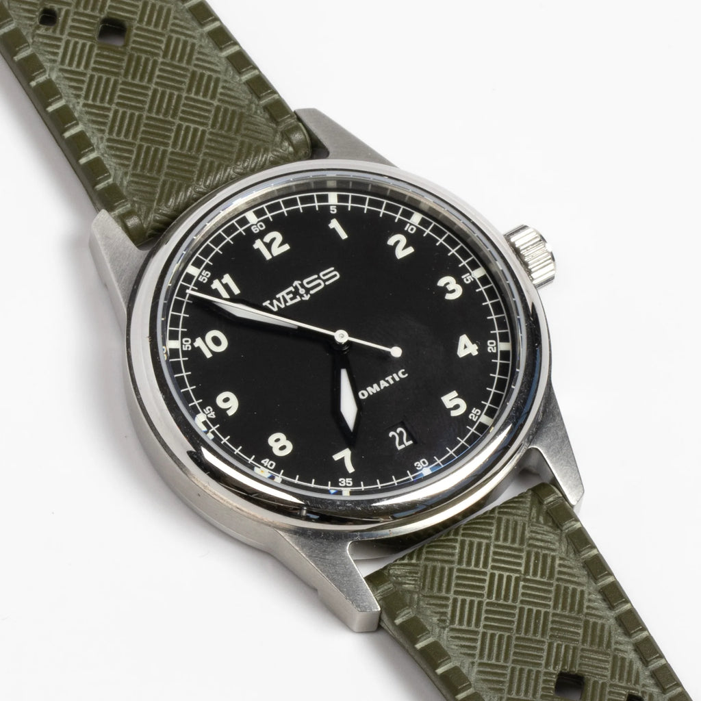 Weiss Watch 38mm Automatic Field Watch with Black Dial and date, shown with  olive rubber strap and white background.