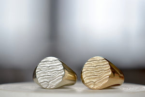 Tidal Round Signets by Fraser Hamilton known as the  'Tidal 11' is a round and solid modern signet ring in 9k yellow or white gold with polished band and matte face, featuring the maker's signature 'low tide' or 'ripple' texture on the face. 