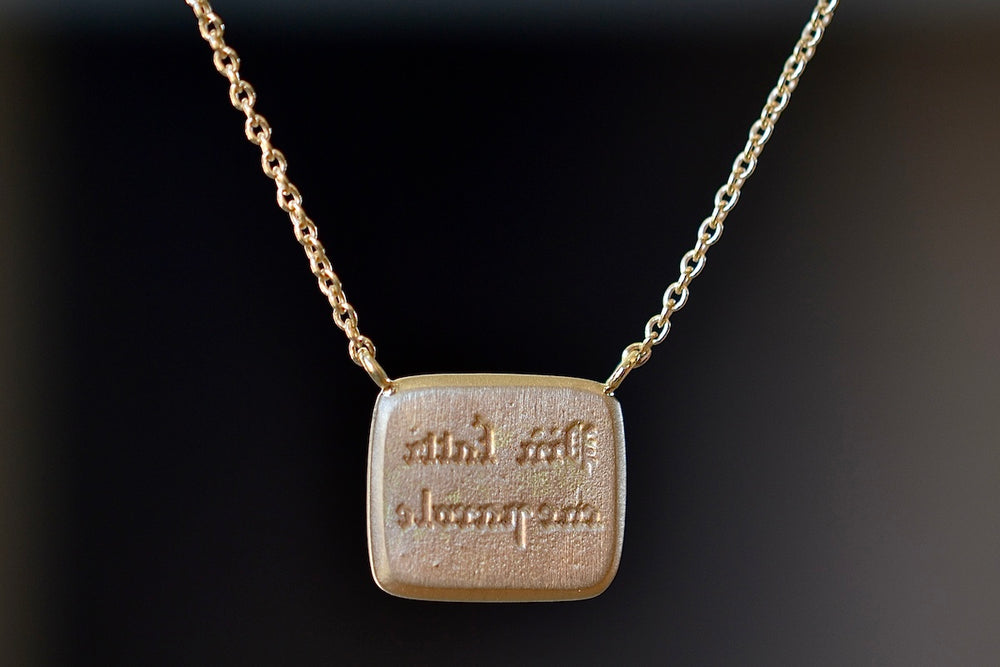 Back of Fearless Motto Necklace with Diamond by Makiko Wakita. Reverse reads In Italian: “Piu Fatti Che Parole” (‘Action Speak Louder than Words.’)