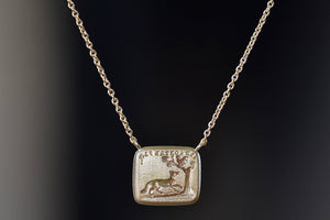 Back of I will Return duo Motto necklace by Makita Wakita is a Made by stamping an 1800s carved seal with 'mottos' in French, Italian, Latin or English on to gold. A rectangular disc in gold and an accent diamond on the front with satin finish that will turn shiny over time. 18" and 18k yellow gold.