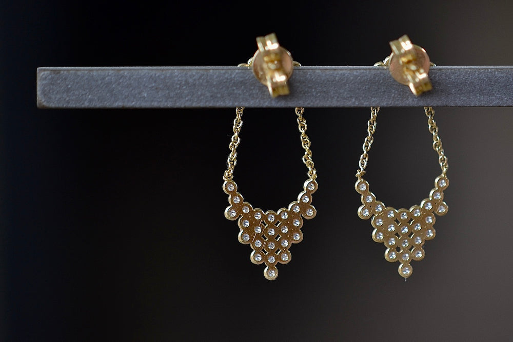 
            
                Load image into Gallery viewer, Back of Pétale Earrings by Yannis Sergakis are an arch of five bezel set and rhodium plated round cut diamonds with gold chains on each end hold together a cascade of twenty-five diamonds in a triangular shape to form a chandelier like earring on post closure in 18k gold. 
            
        