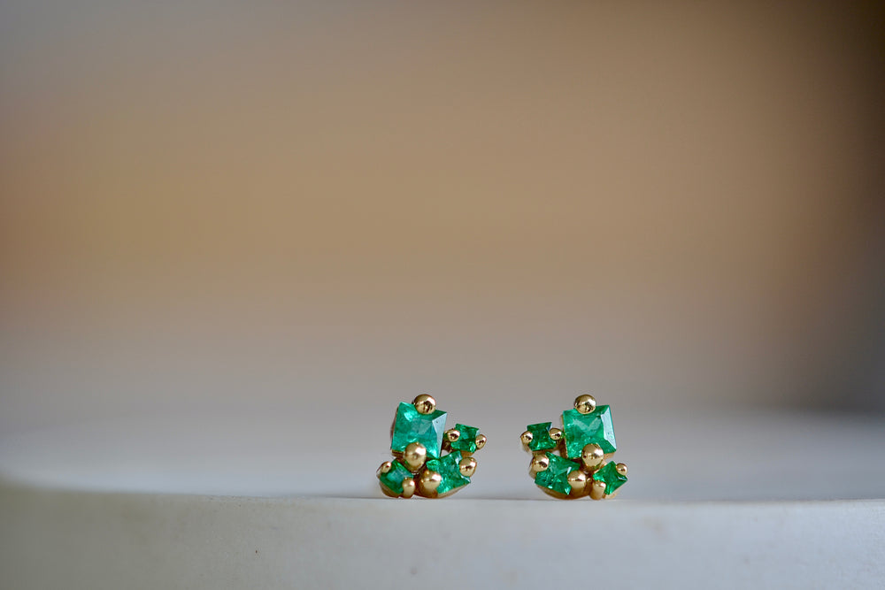 Close up of 18k Princess Emerald Studs earrings with post closure by Suzanne Kalan.