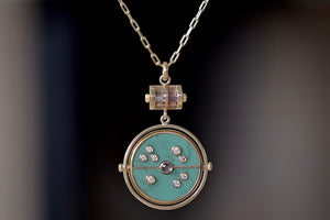 Close up of  Grandfather Compass Pendant in Green Turquoise and Tanzanite by Retrouvai is a pendant necklace with stone inlay that is accented with a center gem stone in the front and back, and nine (9) round white diamonds.