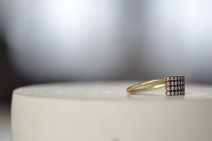 Side view of Charnières Rectangular Ring designed by Yannis Sergakis is a rectangular formation of twenty-eight bezel set and rhodium plated round cut diamonds on a gold band in 18k gold. 