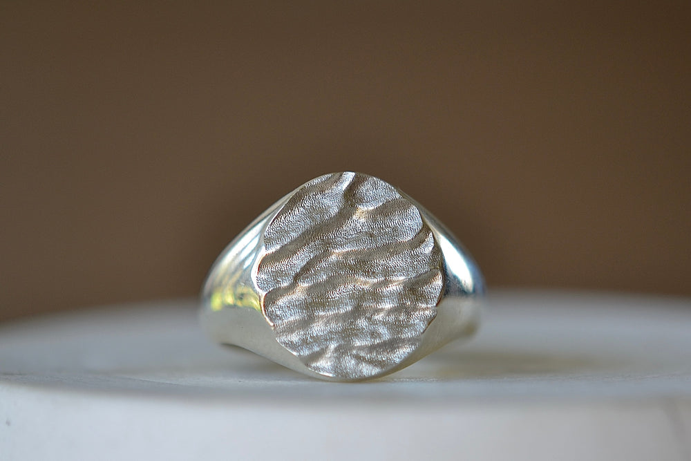 Close up of White gold Tidal round signet by Fraser Hamilton.