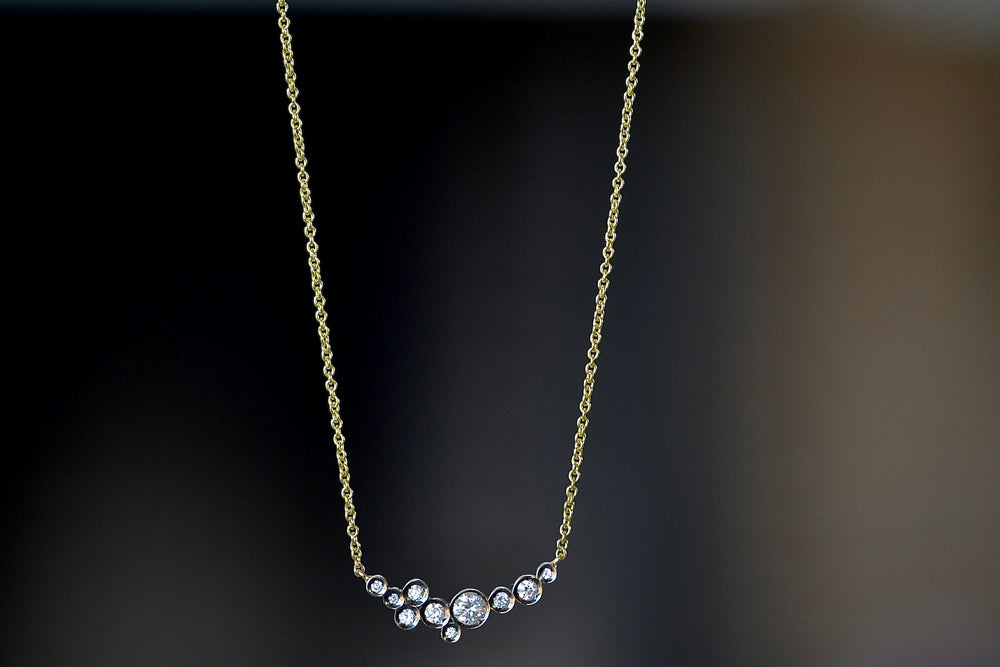 The Celeste necklace by Yannis Sergakis is made out of Ten bezel set and rhodium plated round cut diamonds form a constellation pendant on an 18k gold chain. Part of the Pétale collection.