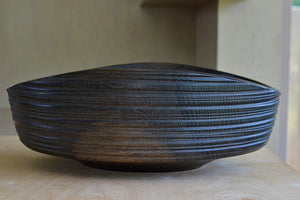 Side view of Circle Factory Bowl in Black Oak with grooves.