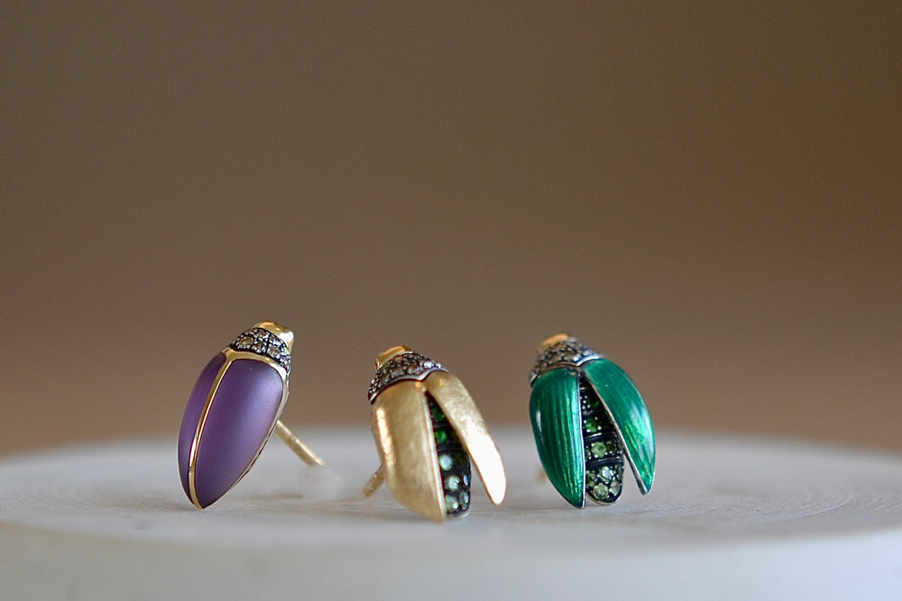 
            
                Load image into Gallery viewer, Scarab studs stud earrings by Bibi Van Der Velden are sculptures/ made in 18k gold with a sterling belly and a stone or wings and stones. Starting from left is an amethysst then a gold with tsavorite and enamel with tsavorite.
            
        