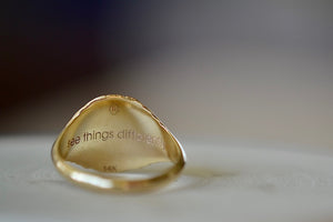 The Retrouvai Baby Fantasy signet pinky ring engraving reads: see things differently.
