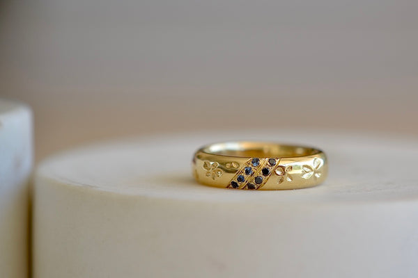 Kaylin Hertel Striped Petal Print Band in Blue is a thick comfort fit band encircled by hand carved petal print and adorned with 3 pave stripes in diamond and dark blue sapphires, white and black diamonds.. 