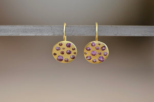 
            
                Load image into Gallery viewer, Polly Wales Celeste Hook Earrings in Lilac Simple ear wires in 18k gold with an attached disc, speckled with lilac to lavender sapphires around the circumference for a beautiful confetti-like appearance. Recycled gold. Cast not set.
            
        