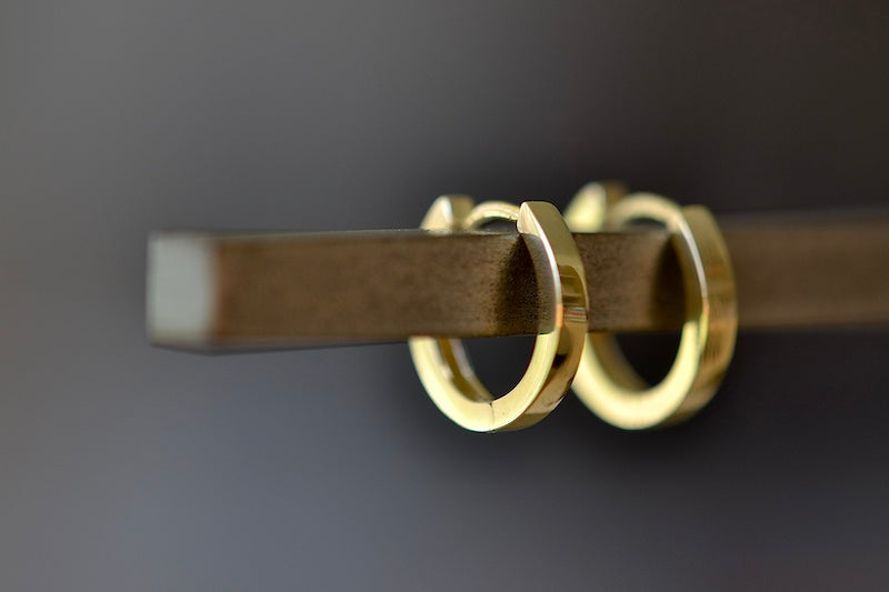 
            
                Load image into Gallery viewer, OK Petite Huggie Hoops are 10mm in diameter, made in 14k yellow gold and designed in Los Angeles.
            
        