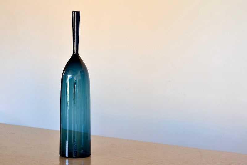 steel blue Angelic Bottles by Joe Cariati are mouth blown  Freeblown by glass master Joe Cariati in his Southern California studio, these bottle-form vases evoke the more mass produced mid-century ones that inspired them, large steel blue.