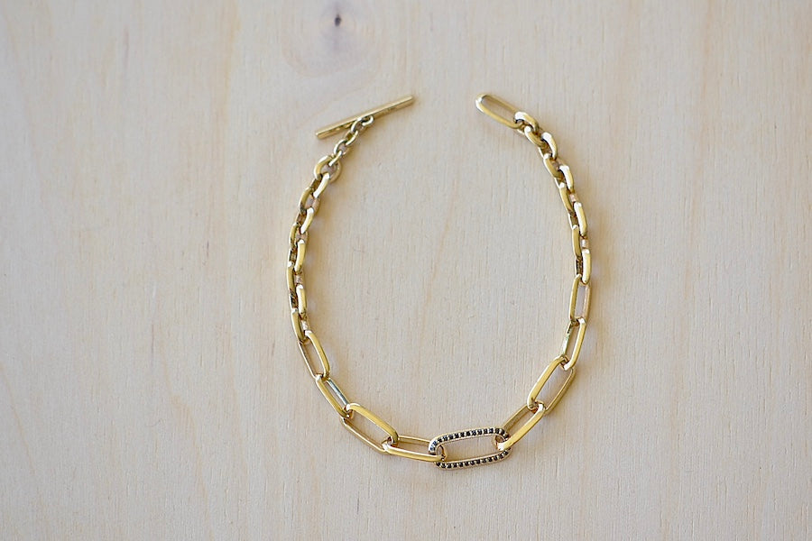 Knife Edge Oval Link Chain Bracelet with Single Pave Link by Lizzie Mandler is a clip bracelet with toggle closure and one pave adorned clip in Othello aka black diamonds on one side and white on the other in 18k yellow gold.