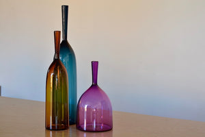 
            
                Load image into Gallery viewer, Angelic Bottles by Joe Cariati are mouth blown  Freeblown by glass master Joe Cariati in his Southern California studio, these bottle-form vases evoke the more mass produced mid-century ones that inspired them, large steel blue, small amber orange and wide ultra violet purple.
            
        