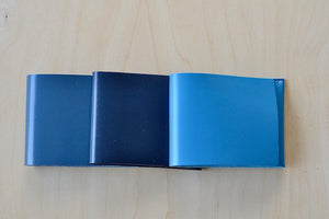 
            
                Load image into Gallery viewer, Simple Flap wallets in gray blue, navy and bright turquoise blue from architect Alice Park shown folded.
            
        