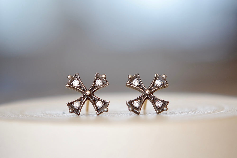 
            
                Load image into Gallery viewer, Oxidized Silver Cross Stud Earrings by Arman Sarkisyan shaped like a cross pattee or templar or iron cross in oxidized silver with gold in the back and diamonds on each segment have post closures.
            
        