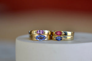 Stoned Slim Cigar Band in purple to lilac Sapphire size 6.5 by Elizabeth street is a marquise cut sapphire in a two prong eagle claw bezel setting on a 14k yellow gold band.