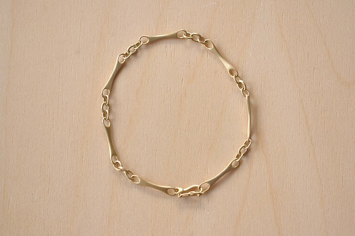 Marian Maurer City Bar Link Bracelet is a curved bone link in her signature smooth and silky 18k yellow gold with satin finish that honors New York City and cities.. This bracelet has a hook and eye closure with a safety to stay on forever.