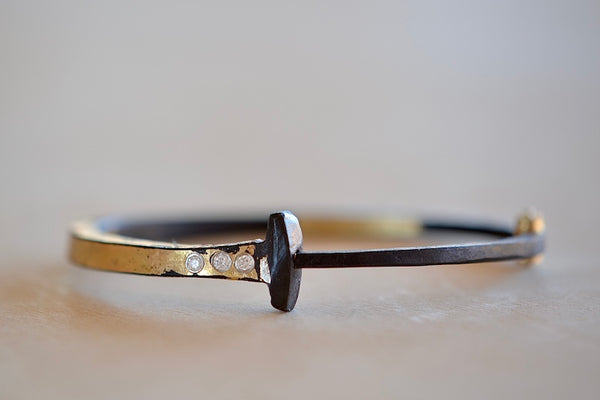 Three Stone Half and Half Nail Bracelet by Pat Flynn is a Forged nail bracelet with half-coverage in 22k fused gold with three (3) accent diamonds and completed with an 18k gold hinge and ball catch closure. Handcrafted in New York.