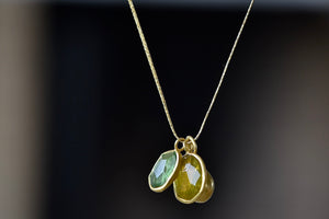 Colette Duo in Green Tourmaline and Lemon Quartz by Pippa Small is a A duo of bezel set, lightly faceted and translucent stones in green Tourmaline and Lemon Quartz that are accompanied by a gold bead and hang on a 17" golden waxed silk cord to form this necklace. 