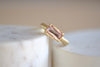 Elizabeth Street Jewelry Eagle Claw Bar ring in light pink peach tourmaline , clear and translucent, tourmaline is a radiant cut pink tourmaline in a four prong eagle claw east/west bezel setting on a 14k satin 3mm yellow gold band size 7..