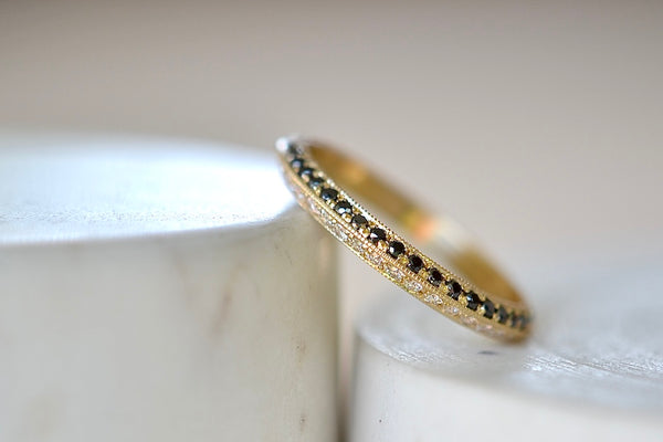 Lizzie Mandler The Othello Knife Edge Band ring by Lizzie Mandler is a wedding engagement band with White diamonds on one side and black round Diamond diamonds on the other in 18k yellow gold.