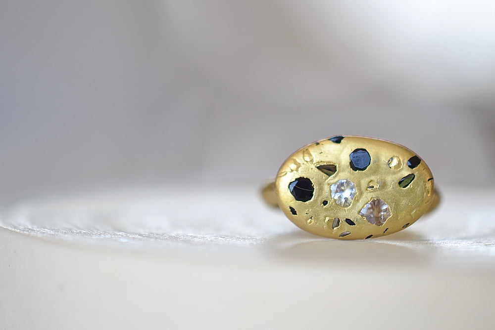 
            
                Load image into Gallery viewer, Polly Wales Elysian Ring with knife edge band in 18k recycled yellow gold with black and white sapphires and cast not set
            
        