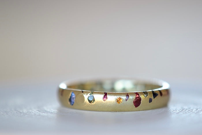 Polly Wales Classic Rainbow Confetti Band Ring in 18k recycled yellow gold with green, yellow, orange, blue, purple and pink sapphires and cast not set size 8.
