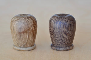 Kay Bojesen "Menagerie" Salt and Pepper shaker set designed in Denmark in oak and smoked oak that is turned 2 3/8" tall and 1 5/8" diameter. Containers have holes on the top and a lid on the bottom with Interior coated with a food safe finish that also protects the containers from color stains.