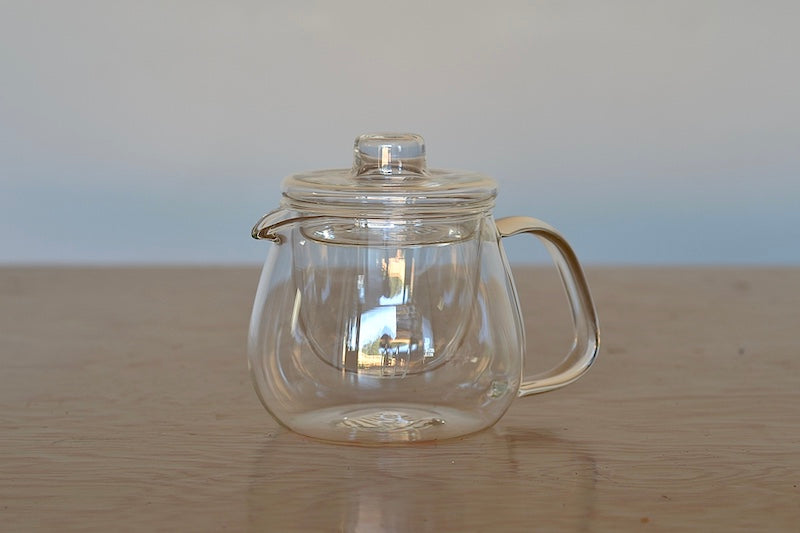 Unitea Glass teapot from Kinto with lid and diffuser and white background..