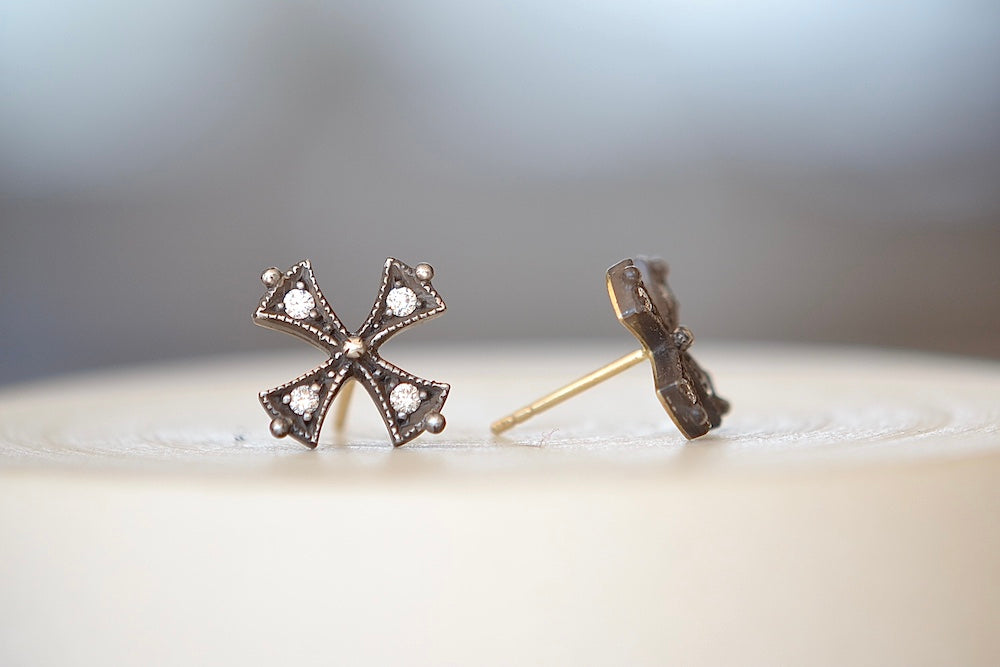 Oxidized Silver Cross Stud Earrings by Arman Sarkisyan shaped like a cross pattee or templar or iron cross in oxidized silver with 22k yellow gold in the back and diamonds on each segment have post closures.