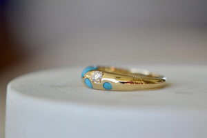 Petite Turquoise Polka Bombe Ring by Retrouvai is a round 14k yellow gold ring made with stone inlay and one round brilliant cut accent diamond (.1CT) with a tapered band that has detailed edging available at OK. Modern and fun.