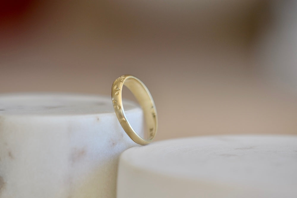 
            
                Load image into Gallery viewer, Kaylin Hertel Slim Tapered Petal Print Band in matte is a tapered version of Kaylin&amp;#39;s classic petal print band with her hand carved petal motif that encircles the round profile band in matte recycled 14k yellow gold.
            
        