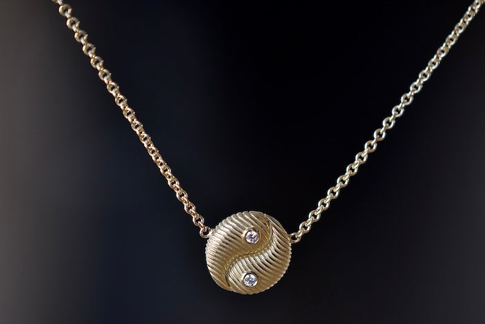 
            
                Load image into Gallery viewer, Retrouvai Mini All Gold Yin Yang Pendant with Diamonds  A unique modern take on an heirloom pendant. A beautifully textured and shaped gold disc accented with two (2) white diamonds hangs on a 16&amp;quot; 14k yellow gold chain.
            
        