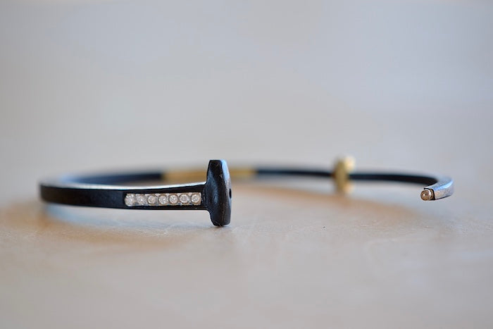 
            
                Load image into Gallery viewer, Pat Flynn Short Stripe Seven (7) Stone Bracelet is a Forged and tapered nail bracelet in blackened iron with seven accent diamonds on one side and completed with an 18k gold hinge and ball catch closure. Handcrafted in New York.
            
        