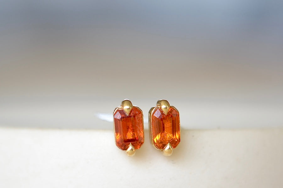 
            
                Load image into Gallery viewer, Eagle Claw Sapphire Studs Earrings by Elizabeth Street are A pair of orange sapphires that are semi bezel set in a two prong eagle claw setting with post closure in 14k satin gold to form these elegant everyday stud earrings. Handmade in Los Angeles.
            
        