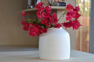 
            
                Load image into Gallery viewer, Lilith Rockett Urn Vase shown with flowers is wheel thrown porcelain with gloss glaze on the interior and an unglazed exterior.
            
        
