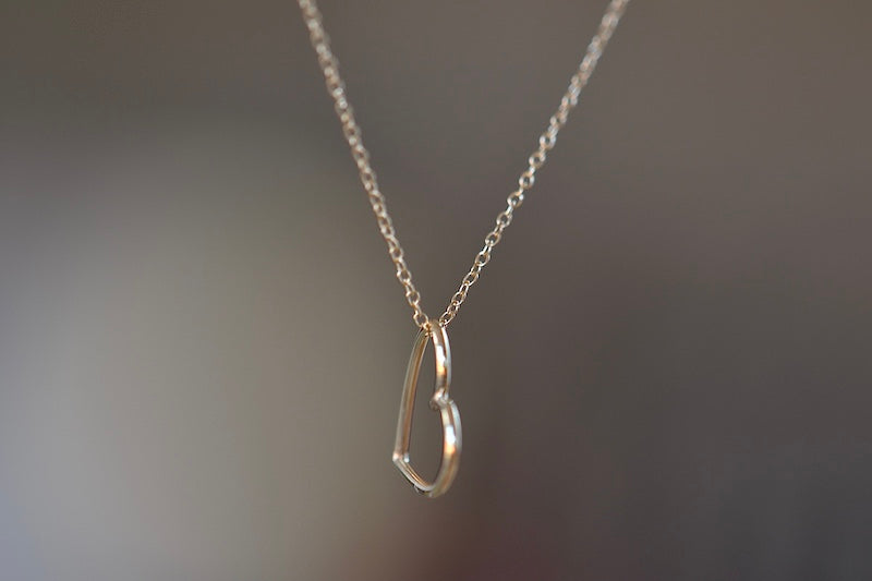 Hortense Sweet Heart Necklace is a heart shaped charm sits loose on a whisper thin 14k yellow gold chain. Very sweet. Handmade in Los Angeles.