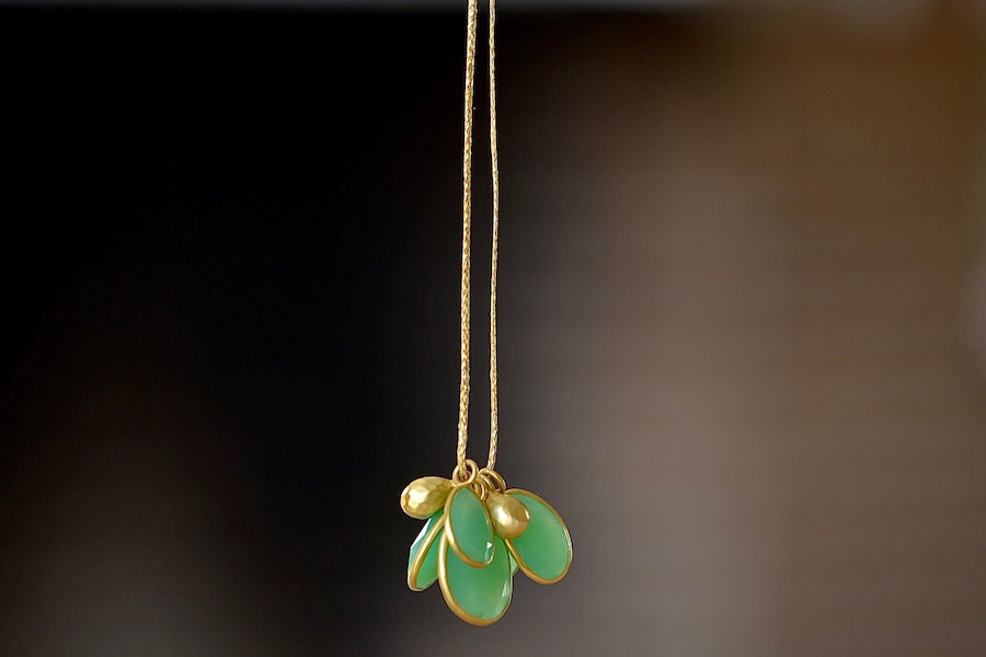 Colette Cluster Necklace in Chrysoprase with Gold Drops designed by Pippa Small is a Cluster of chrysoprase pendants bezel set stones in various sizes with two (2) 18k gold beads on 22" golden waxed cotton cord also known as the Flourishing Green necklace.