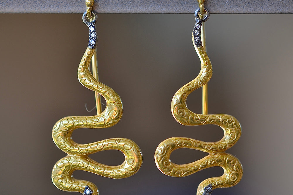 
            
                Load image into Gallery viewer, Detail of Snake Drop Earrings by Arman Sarkyssian are 22k gold snakes with oxidized sterling silver details, accent  pavé diamonds and engraved details on earring hooks. 
            
        