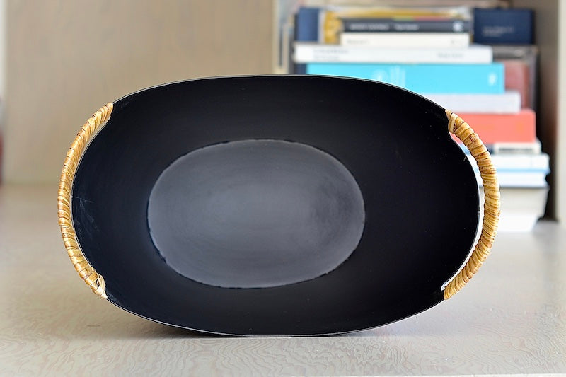 The Ørskov Wastebasket is made in matte black steel with cane wrapped handles and is 13" tall. It was designed by Grethe Kornerup-Bang in Denmark and is still  produced by Torben Orskow.