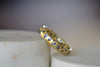 The Cornflower Blue Sapphire Confetti Band designed by Polly Wales is a narrow 18k yellow recycled gold wedding band/ring with speckled ombre light blue sapphires around the circumference. It is cast not set and handmade in Los Angeles.