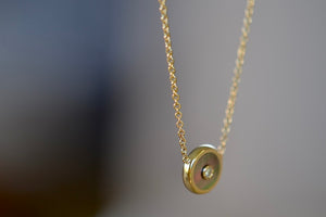 
            
                Load image into Gallery viewer, Side view of Mini compass pendant in dark mother of pearl by Retrouvai.
            
        
