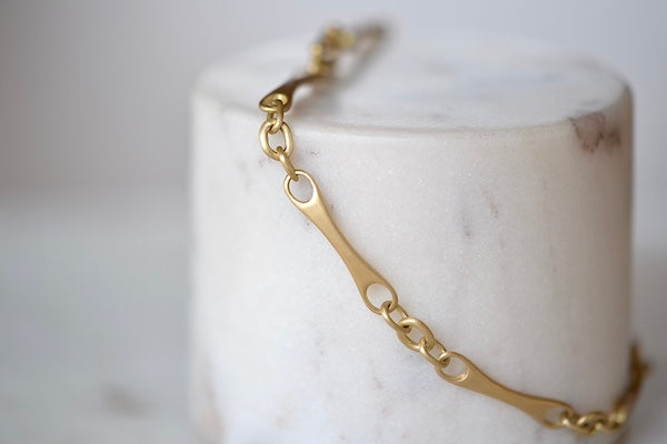 Marian Maurer City Bar Link Bracelet is a curved bone link in her signature smooth and silky 18k yellow gold with satin finish that honors New York City and cities.. This bracelet has a hook and eye closure with a safety to stay on forever.
