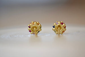 
            
                Load image into Gallery viewer, Polly Wales Small Sputnik Stud Earrings in Rainbow are domed half spheres in 18k yellow gold with encrusted and inverted red, pink, blue, green, yellow and orange sapphires around the circumference with post closure. Cast not set. Recycled Gold.
            
        